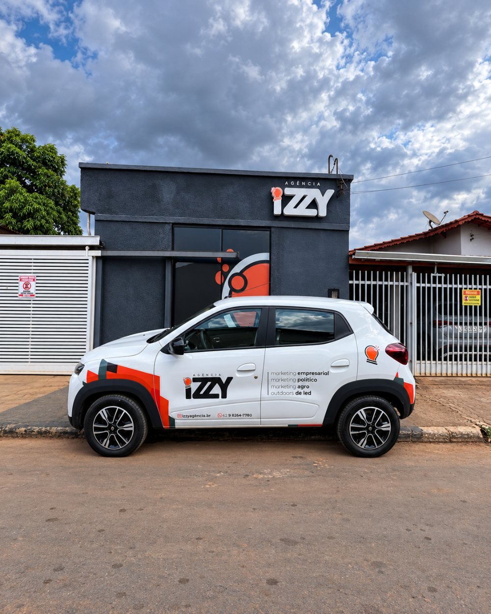 Carro adesivado da Agência Izzy diante da sede